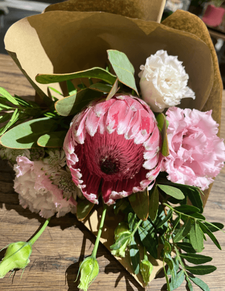 BOUQUET FAUSTA Protea fucsia con lisianthus bianco e rosa e verdi misti
