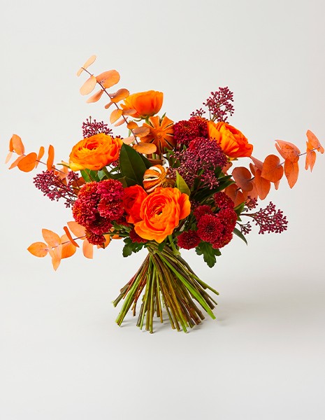 Bouquet Fiorenza con ranuncoli arancio e fiori dai toni bronzo