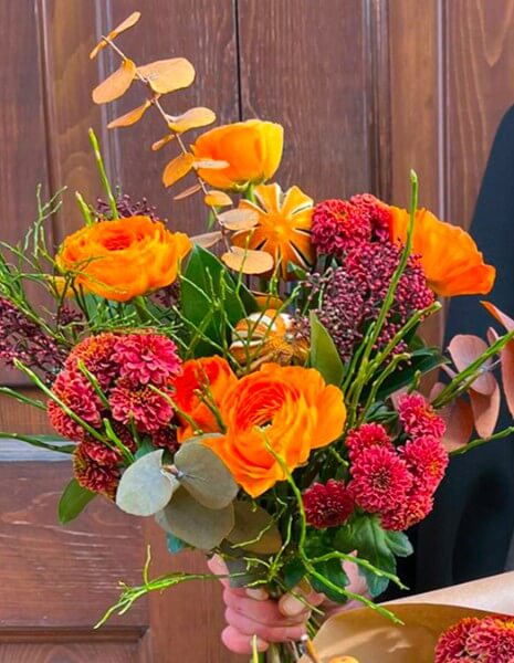 BOUQUET FIORENZA Ranuncoli arancio con skimmia arancio-bronzo, elementi secchi